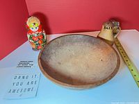 Group shot showing wood bowl, ceramic salt shaker, matryoshka doll with scale