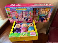 Full view of Barbie Pet Daycare set and Cabbage Patch Kids Enchanted Forest Friends dolls in original packaging side by side on carpeted floor.
