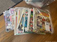 Mixed comic books from Marvel and other publishers, all in plastic protective sleeves, showing varied colorful superhero covers.