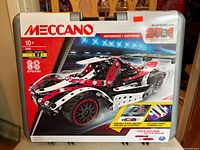Front of original Meccano packaging showing motorized supercar in red, black, and silver with 27 in 1 model indicator.