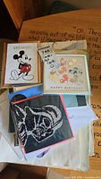 Top view of several Papyrus collectible cards and art cards including Mickey Mouse birthday cards and Darth Vader design