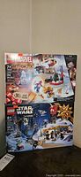 Front view showing both Marvel and Star Wars LEGO Advent Calendar boxes stacked vertically, sealed.