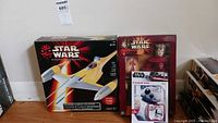 Photo showing boxed Star Wars Episode 1 electronic Naboo fighter and boxed Queen Amidala figure with a box of 16 Star Wars Valentine masks in front