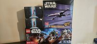 Four Star Wars boxes arranged showing LEGO set, X-Wing Fighter, and two Droid Fighter kits all new and sealed.