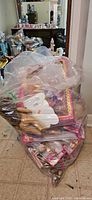 Large bag packed with multiple dolls, mostly still in original sealed packaging.