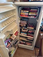Wide shot of upright freezer interior filled with VHS tapes