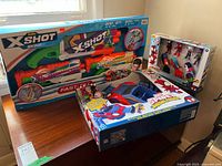 Two boxed Zuru X-Shot Skins water blasters with Spider-Man designs and two Marvel Spidey Amazing Friends sets, all new and boxed.