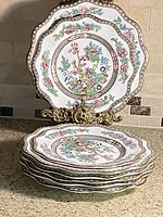 Stack of eight scalloped plates with stand, showing overall set