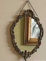 Front view of mirror showing ornate frame and hanging chain