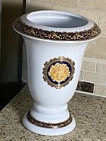 Full view of white porcelain vase with blue and gold trim