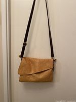 Full view of leather crossbody bag hanging to show size and strap length
