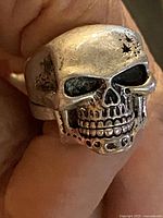Front view of skull ring worn on finger showing overall design