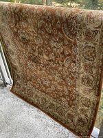 Full view of rug hung over railing showing pattern and colors