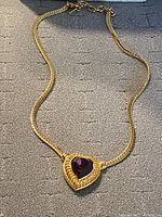 Full view of gold-tone chain necklace with heart pendant