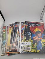 Stack of 15 Superman comic books from the 1990s showing front covers with colorful artwork and various action scenes.