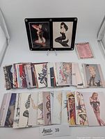 A group of 39 Olivia collector cards laid out, various artistic pin-up illustrations mainly female figures in lingerie, some cards featuring close-up or partial images.