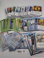 Over 60 Chaotic TCG cards spread out showing varied colors and types including green, white, and blue cards.