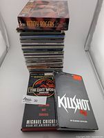 Stack of country music CDs topped with Kenny Rogers sealed 3-CD set in box. Various artist names visible on spines.