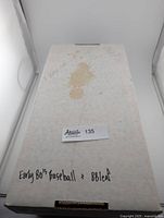 Closed white cardboard box labeled 'Early 80's baseball + 88 leaf' with visible stains on top.