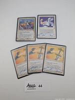 Five Magic the Gathering cards arranged with four Disenchant cards and one Bayou card, all showing artist signatures.