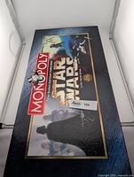 Closed Monopoly Star Wars Classic Trilogy Edition game box with Star Wars character artwork and Monopoly logo.