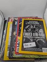Stack of magazines and books showing National Geographic pandemic cover, TIME Disney cover, and others