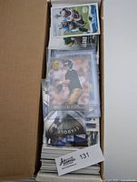 Box with stacks of football cards showing a Brett Favre card on top and assorted cards underneath.