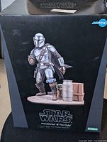 Front view of sealed box featuring The Mandalorian and The Child statue image, with Star Wars branding and ARTFX logo.
