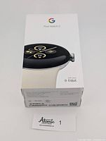 Front of sealed Google Pixel Watch 2 box showing branding, watch face image and porcelain band