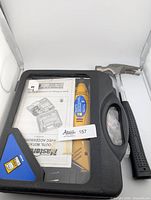 Rotary tool in black case with accessories and user manual, alongside Mastercraft hammer