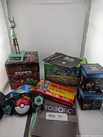 Rick and Morty figurine on display stand, Mario Super Shakers box, Aliens blind box, Buffy bookmark, and various fridge magnets including Pokémon-themed wearable strap and ninja star magnets.