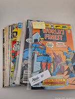 Stack of 12 World's Finest comics with visible colorful covers featuring Superman and Batman action scenes, protected in clear sleeves.