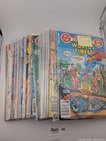 Stack of 24 vintage World's Finest comic books from the 1980s, individually packed in plastic sleeves, showing colorful covers featuring Superman and Batman.