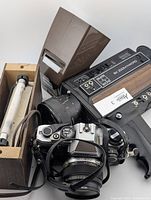 Side angle showing Olympus camera, Sears Power Zoom XL camera with zoom lens and pistol grip, along with slide viewer and blacklight