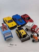 Seven vintage toy vehicles including hotrod car, bulldozer, trucks, and race car