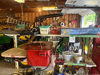 Wide view of the top two shelves with assorted tools and accessories including drill bits and polishing tools, showing shelf labels and multiple containers.