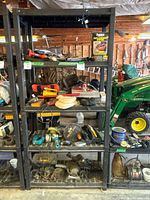 Overall shelving unit with assorted garage and workshop tools and parts.