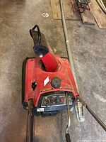 Top-down view of red Honda HS35 snow blower showing gas cap, control panel with knobs and levers, and chute.