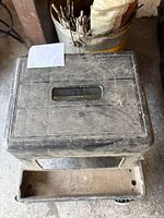 View of the dirty, heavily worn plastic Workside toolbox with handle, showing surface scratches and dirt.
