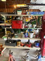 Full view of the metal storage shelf laden with various household and workshop items such as paint cans, tools, and containers.