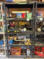 Front view of black plastic shelving unit with various garage items placed on multiple shelves.
