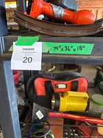 Close-up of shelf labeled with dimensions 74" x 36" x 18" and containing red cordless drill and other tools