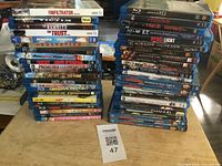Top view showing two stacks of Blu Ray movies, titles visible include Infiltrator, Horns, ET, and Transformers, among others