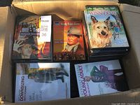 Photo showing a box containing several DVD movie cases, titles visible include Bill & Ted's Bogus Journey, Randy Rides Alone, The Incredible Journey, Downsizing, and The Young Adult.