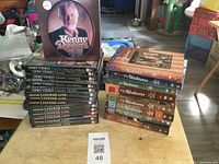 Photo showing one stack of DVDs with Opry Video Classics and Country Legends Live DVDs along with The Waltons DVDs and the Kenny Rogers picture disc CD on top.