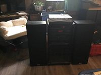 Full view of stereo system showing main unit between two large speakers