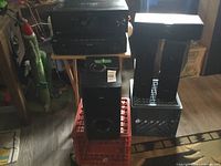 Full setup showing the receiver with 5-disc CD player on top, two tall speakers on crate, and subwoofer on red crate.