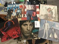 Photo showing all six rock vinyl LP albums arranged on a surface, including Best of Blondie, Bruce Springsteen's The River, Foreigner's Double Vision, Ringo Starr's Goodnight Vienna, Bob Seger & The Silver Bullet Band, and one additional live album with a red crowd cover.