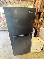 Full view of the black Magic Chef top freezer refrigerator showing front and handle.