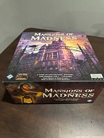 Box cover showing front artwork of Mansions of Madness Second Edition by Fantasy Flight Games with atmospheric mansion art and title.